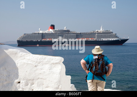 American tourists with Queen Victoria cruise ship in background on Mykonos, Greece Stock Photo