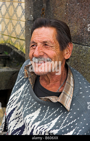 Portrait older wrinkled man sitting by fountain in town of Furnas Sao Miguel Azores Islands Portugal Stock Photo