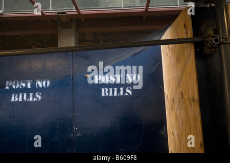 Post no bills is painted in white letters on a blue wooden wall around a construction area in New York 23 November 2008 Stock Photo