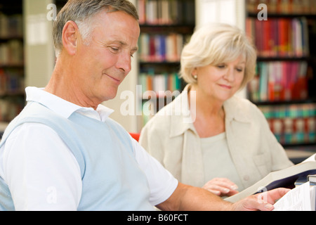 Man and woman in library reading (selective focus) Stock Photo