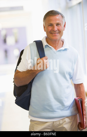 Man standing in corridor with backpack (high key) Stock Photo