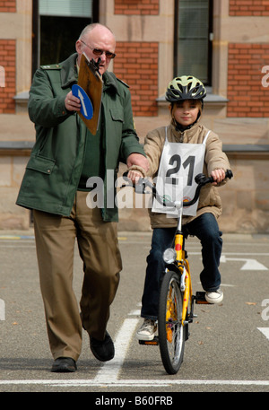 Traffic Education, 10-year-old girl on a bicycle beside a police officer Stock Photo