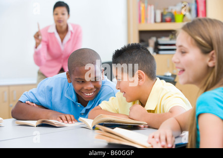 Students in class talking with teacher in background (selective focus) Stock Photo