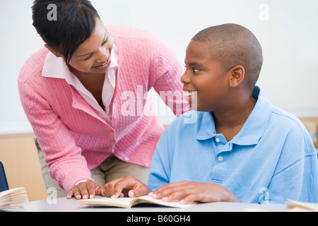 Student in class reading with teacher Stock Photo