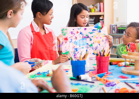 Student showing teacher and classmates her artwork (selective focus) Stock Photo