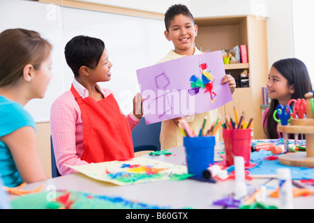 Student showing teacher and classmates his artwork (selective focus) Stock Photo