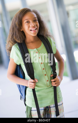 Student standing outside school smiling (selective focus) Stock Photo