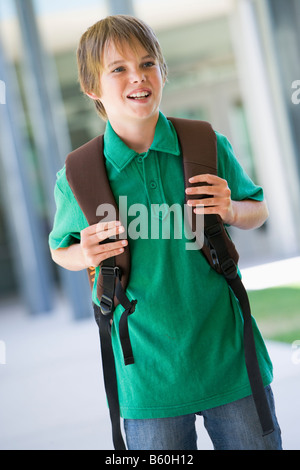 Student standing outside school smiling (selective focus) Stock Photo