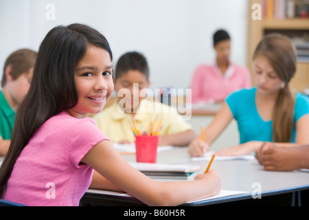 Students in class taking notes with teacher in background (selective focus) Stock Photo