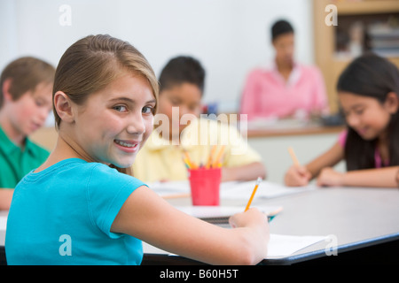 Students in class taking notes with teacher in background (selective focus) Stock Photo