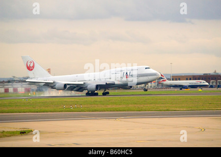 A Jumbo jet Boeing 747 landing on a runway at Heathrow. Stock Photo