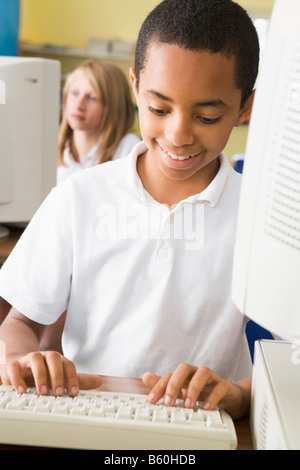 Student at computer terminal typing with student in background (selective focus) Stock Photo