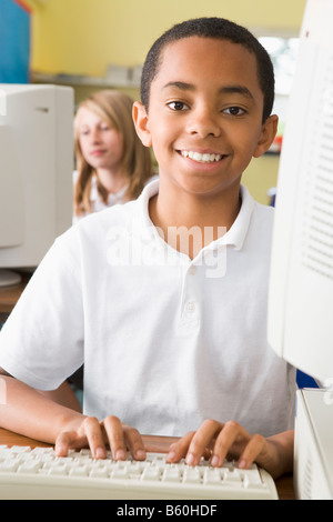 Student at computer terminal typing with student in background (selective focus) Stock Photo