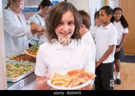 Students in cafeteria line with one holding unhealthy meal looking at camera (depth of field) Stock Photo