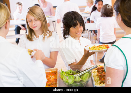 Students in cafeteria line being served by lunch ladies Stock Photo