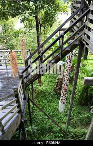 Steep narrow ladder and decorated stilts of native house in Sarawak, Malaysia. Stock Photo