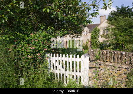 The garden gate to a rustic stone cottage in the Cotswold village of Swinbrook, Oxfordshire Stock Photo