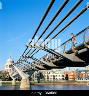A woman tourist standing on the Millennium Bridge looking at the River Thames and Saint Pauls Cathedral London England UK   KATHY DEWITT Stock Photo