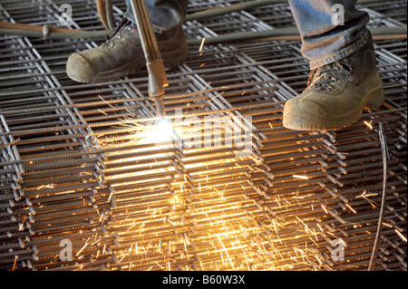 Cutting steel reinforcing mesh with a cutting torch Stock Photo