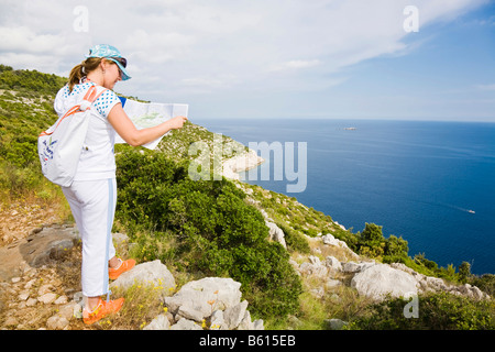 Young woman reading a map, Mljet Island, Dubrovnik-Neretva, Dalmatia, Croatia, Europe Stock Photo