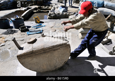 Child labour, 14 year old boy grinding stone containing ore, tin, zinc, to a fine powder, Llallagua mining centre, Potosi Stock Photo