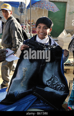 Child labour, 10-year-old boy selling trousers on El Alto market, La Paz, Bolivia, South America Stock Photo
