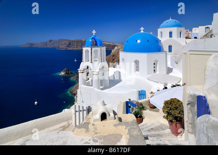 Blue and white domed church and bell tower in front of the blue sea, Oia, Ia, Santorini, Cyclades, Greece, Europe Stock Photo