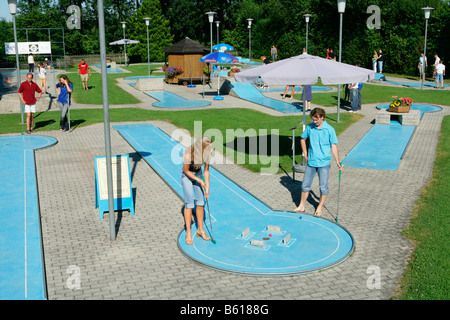 Young couple playing mini golf, county of Muehldorf, Upper Bavaria Stock Photo