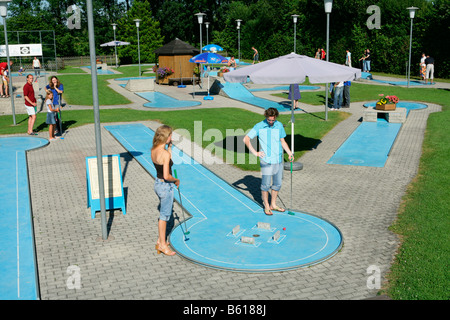 Young couple playing mini golf, county of Muehldorf, Upper Bavaria Stock Photo