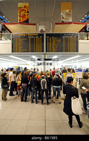 Passengers with baggage queueing up for check-in at the passenger