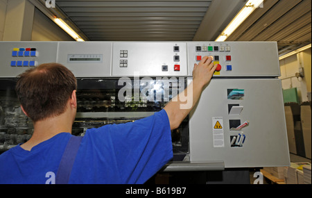 Printer operating a Heidelberg Speedmaster printing press in a printing house Stock Photo