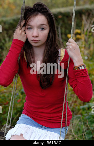 Teenage girl looking sad sitting on a swing