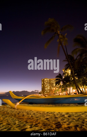 A outrigger canoe on Waikiki beach in Honolulu, Oahu, Hawaii at dusk. Stock Photo