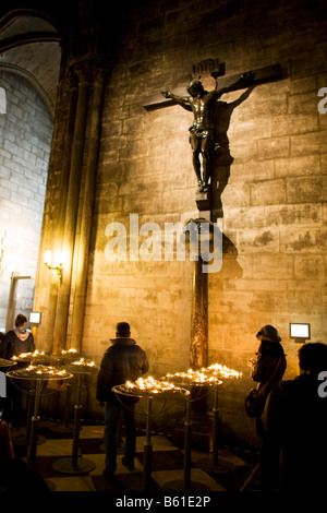 Visitors observe a crucifix inside Paris’ Cathedral of Notre-Dame Stock Photo