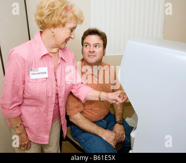 Voter receiving instructions on using a new machine from a volunteer Stock Photo