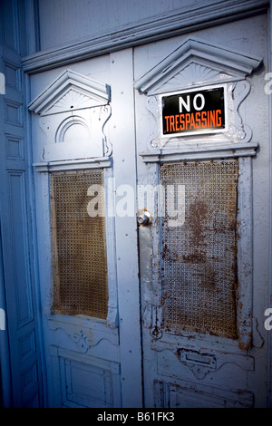 No Trespassing sign on the front door of an abandoned house. Stock Photo