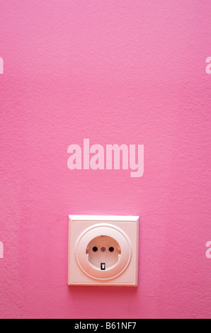 Electrical outlet on a pink wall Stock Photo