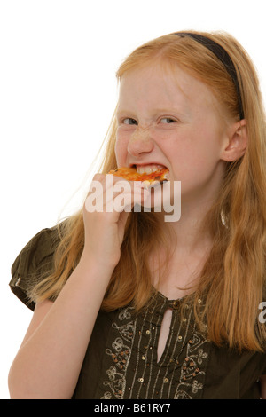 Girl, 8, biting heartfully into a piece of pizza Stock Photo