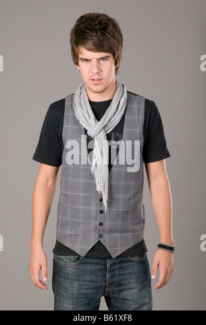 Young man standing in front of gray wall Stock Photo