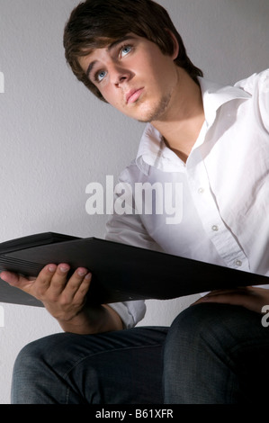Young man holding a file in his hands and looking upwards Stock Photo