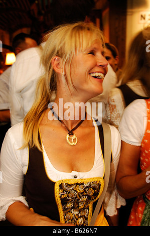Woman wearing a traditional dress, called a Dirndl, in a beer tent at the Oktoberfest Beer Festival or Wies'n in Munich, Bavari Stock Photo