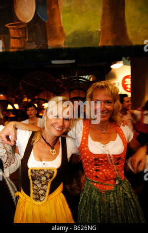 Women wearing traditional dress, called a Dirndl, dancing in the Beer Tent at the Oktoberfest Beer Festival or Wies'n in Munich Stock Photo