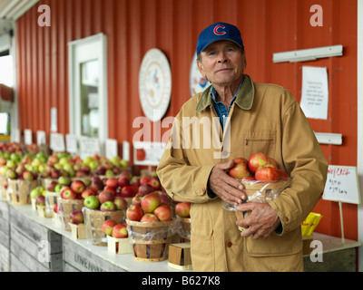 A man holds a bushel of apples at a orchard in upstate New York. Stock Photo