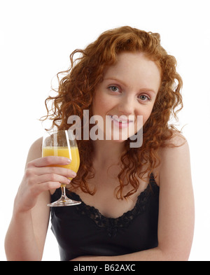 Young woman at breakfast table with glass of orange juice Stock Photo