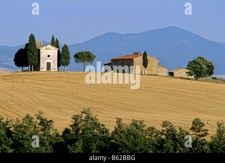 Capella di Vitaleta and farmhouse in the Val d' Orcia near San Quirico d' Orcia in front of Monte Amiata, Province of Siena, Tu Stock Photo