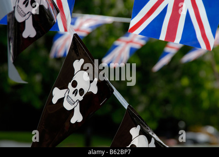 Jolly Roger pirate pennants and Union Jack flags strung up on a narrowboat, Little Venice, London, England Stock Photo