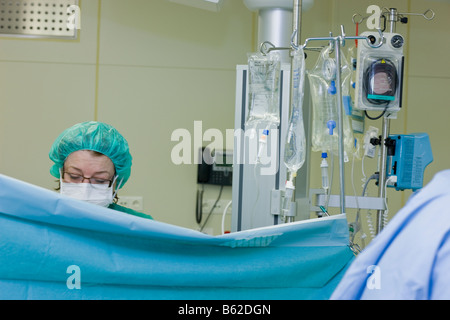 Surgial nurse monitoring patient during neurosurgery to remove a benign brain tumor, Reykjavik Iceand Stock Photo