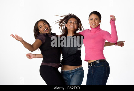 Asian Black and Latino young women laughing and jumping together on a white background Stock Photo