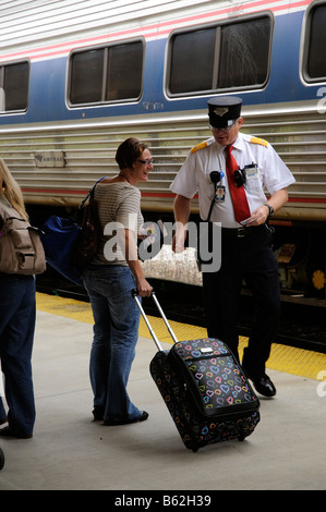 Amtrak railroad conductor assisting passenger at Deland Fl America USA DeLand Train Station Florida America USA Stock Photo