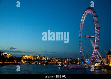 The London Eye at night along the River Thames in London England Stock Photo